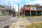 A long street with tall telephone poles and colorful wall murals and bare winter trees and tall curved light posts with blue sky