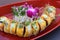 Long sushi roll filled with the freshest ingredients covered in mango slices