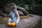 A long tailed grey monkey sitting and eating a fresh orange, UBUD MONKEY FOREST, BALI, INDONESIA