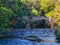 Long time exposure of a creek with an ancient stone bridge in an