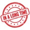 IN A LONG TIME text on red grungy round rubber stamp