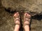 Long tired naked legs in hiking sandals on peak. Hiking in sandstone rocks, hilly landscape