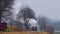 Long View of a Steam Passenger Train Rounding a Bend, Blowing Smoke