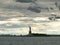 Long view of storm clouds and silhouetted statue of liberty