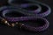 Long violet bead necklace on a dark background