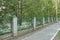 A long wall of green metal and white brick fence on the street