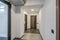 Long white empty corridor in interior of entrance hall of modern apartments, office or clinic