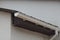 Long white plastic gutter pipe on brown gray wall