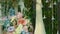 Long white wedding dress hangs on the pine tree in a clearing in the woods.