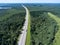 Long and wide highway going to horizon, freight semitrailer drives on lane, aerial view