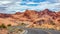 Long winding highway with ups and downs, cloudy blue sky. Valley of Fire Nevada, USA