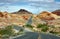 Long winding highway with ups and downs, cloudy blue sky. Valley of Fire Nevada, USA