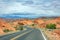 Long winding highway with ups and downs, cloudy blue sky. Valley of Fire Nevada, USA