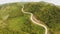 A long and winding road passing through green hills. Busuanga island. Coron. Aerial view. Philippines.