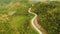 A long and winding road passing through green hills. Busuanga island. Coron. Aerial view. Philippines.