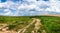 Long and winding rural road crosses the hills and fields