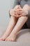 Long woman legs with smooth soft skin on sofa, couch or bed. A woman sits in a cozy home or apartment closeup. Woman