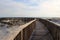 Long wood pier leading guests out to the sandy beach and ocean