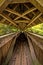 Long wooden beamed pedestrian bridge with roof