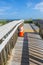 Long wooden boardwalk with damage and orange reflective warning cones