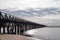 Long wooden boardwalk pier leads from one beach to another over a small ocean inlet