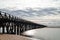 Long wooden boardwalk pier leads from one beach to another over a small ocean inlet