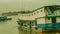 Long wooden boat loaded by passengers and goods cruising Mahakam River, East Borneo.