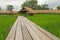 Long wooden bridge to grass pavilion