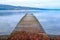 A long wooden jetty on a lake, looking out over a clear calm blue lake, winderemere, England