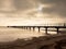 Long wooden pier at coast, cold morning, peaceful silent day