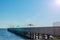 Long wooden pier with large sun shade umbrellas.