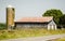 Long, Wooden Rustic Barn with Silo on a Country Road