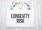 LONGEVITY RISK text written on paper with pen and glasses