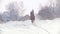 Longhaired female rider wild and fast riding black horse through the snow, slow-motion