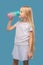 Longhaired girl in white clothes drinking water