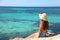 Longing for summer, longing for holidays. Back view on female tourist enjoying view crystalline water of the ocean