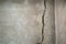 Longitudinal cracks in concrete cement wall in the house where no people to live. White cement construction material texture.