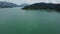 Longtail boat cruising on a lake surrounded by mountains