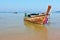 A Longtail boat in orange beach sand