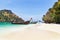 longtail boats mooring on the beach between small limestone islands in andaman sea