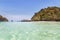 longtail boats mooring on the beach between small limestone islands in andaman sea at Krabi, Thailand