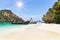 longtail boats mooring on the beach between small limestone islands in andaman sea Thailand