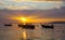 Longtail boats on seashore at sunset