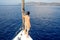 Look beyond the horizon, man in shorts stands on the deck near the sail, sailing and yachting, concept.