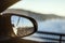 Look of bridge road and sea reflected in rear-view mirror while driving through the bridge