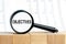 Look closely and OBJECTIVES with a magnifying glass , business concept image with soft focus background