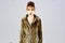 Look of fashion model with bad taste. Leopard fur at stylish girl. Woman in leopard fur coat on grey background. Fur