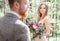 Look from groom& x27;s shoulder at stunning brown-haired bride