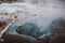 Look inside splendid colorful source of geothermal water on the territory of Geysir, Southwestern Iceland. Blue and white ground