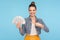 Look at money! Happy excited rich woman with hair bun in modern outfit pointing at fan of dollars in her hand and smiling